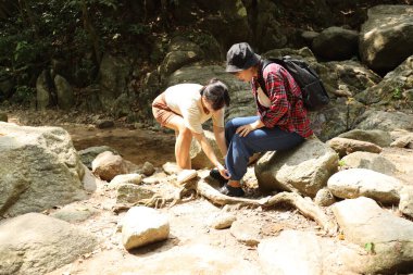 İki Asyalı kardeş yaz mevsiminde gündüz vakti gölün kenarında birlikte vakit geçiriyorlar..