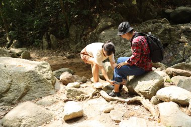 İki Asyalı kardeş yaz mevsiminde gündüz vakti gölün kenarında birlikte vakit geçiriyorlar..