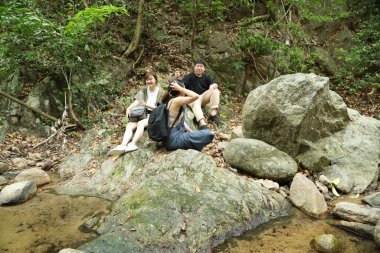 Üç Asyalı arkadaş yaz mevsiminde gündüz vakti gölün kenarında birlikte vakit geçiriyorlar..