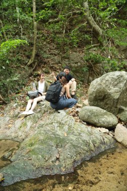 Üç Asyalı arkadaş yaz mevsiminde gündüz vakti gölün kenarında birlikte vakit geçiriyorlar..