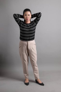 Gri arka planda duran 40 'lı yılların Doğu Asyalı kadını..