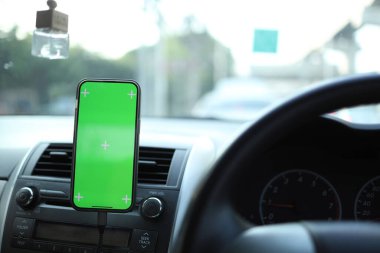 Adam araba kullanıyor ve şehirde izole edilmiş ekranı olan bir navigatör olarak akıllı telefonu kullanıyor..