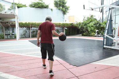 Basketbol sahasında basketbol oynayan neşeli, aktif, son sınıf öğrencisi..