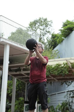 Basketbol sahasında basketbol oynayan neşeli, aktif, son sınıf öğrencisi..