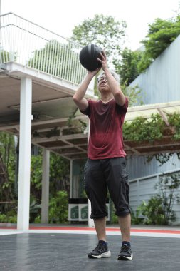 Basketbol sahasında basketbol oynayan neşeli, aktif, son sınıf öğrencisi..