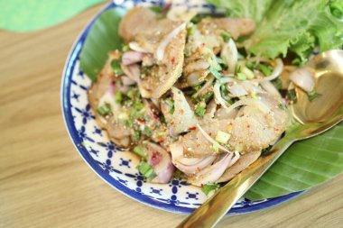 Tayland usulü ızgara domuz salatası tabakta servis edilir..