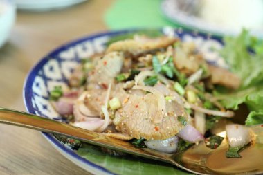 Tayland usulü ızgara domuz salatası tabakta servis edilir..
