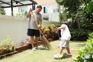 Güneydoğu Asyalı aile gündüz vakti birlikte bahçe işleri yapıyor..