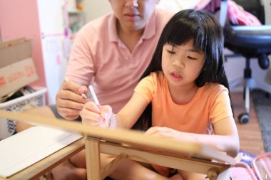 Doğu Asyalı baba ve kızı evde birlikte vakit geçiriyorlar..