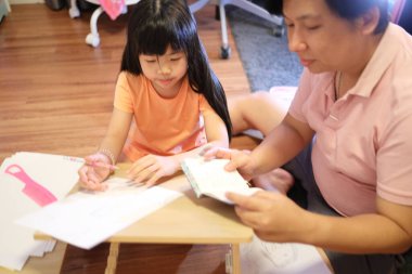 Doğu Asyalı baba ve kızı evde birlikte vakit geçiriyorlar..