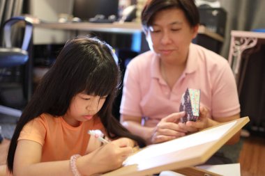 Doğu Asyalı baba ve kızı evde birlikte vakit geçiriyorlar..