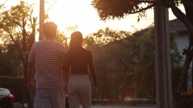 Asyalı aile akşam vakti küçük parkta dinleniyor..