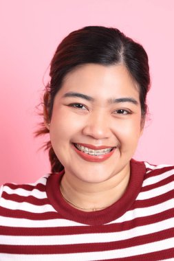 Renkli arka planda diş telleri olan Güneydoğu Asyalı kadın..