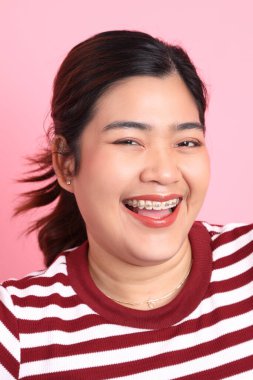 Renkli arka planda diş telleri olan Güneydoğu Asyalı kadın..