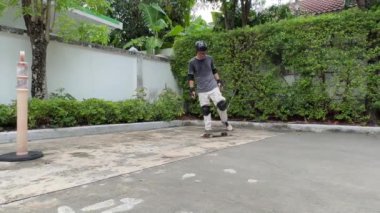 Kıdemli Asyalı gün içinde köyde kaykay sürmeye çalışıyor.