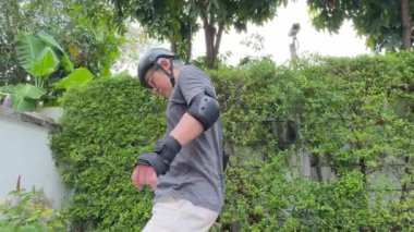 Kıdemli Asyalı gün içinde köyde kaykay sürmeye çalışıyor.