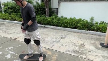 Kıdemli Asyalı gün içinde köyde kaykay sürmeye çalışıyor.