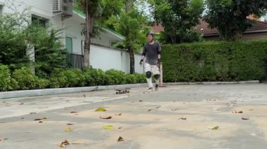 Kıdemli Asyalı gün içinde köyde kaykay sürmeye çalışıyor.