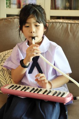 Okuldan sonra Doğu Asyalı çocuk melodi çalışıyor..