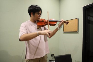 Güneydoğu Asyalı adam keman çalıyor..