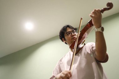 Güneydoğu Asyalı adam keman çalıyor..