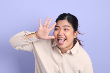 Renkli arka planda diş telleri olan Güneydoğu Asyalı kadın..