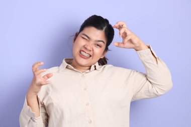 Renkli arka planda diş telleri olan Güneydoğu Asyalı kadın..