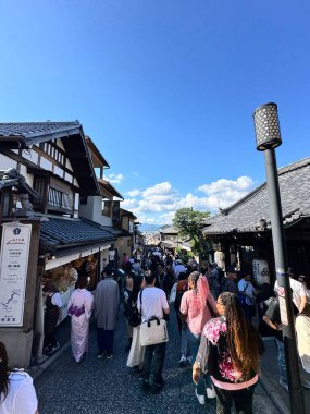 Kyoto, Japonya - 12 Ekim 2024: Kalabalık insanlar Japonya 'nın Kyoto kentindeki ünlü tapınak Kiyomizu-dera' ya giden alışveriş caddesinde yürüyorlar.