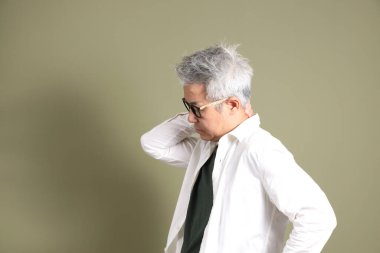 Doğu Asyalı bir işadamının yarım vücut portresi. Koyu yeşil bir arka planda izole edilmiş. Stüdyoda çekilmiş..