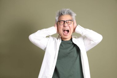 Doğu Asyalı bir işadamının yarım vücut portresi. Koyu yeşil bir arka planda izole edilmiş. Stüdyoda çekilmiş..