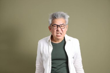 Doğu Asyalı bir işadamının yarım vücut portresi. Koyu yeşil bir arka planda izole edilmiş. Stüdyoda çekilmiş..