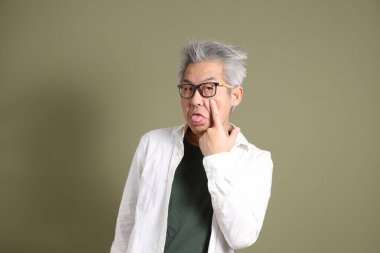 Doğu Asyalı bir işadamının yarım vücut portresi. Koyu yeşil bir arka planda izole edilmiş. Stüdyoda çekilmiş..