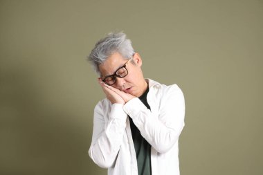 Doğu Asyalı bir işadamının yarım vücut portresi. Koyu yeşil bir arka planda izole edilmiş. Stüdyoda çekilmiş..