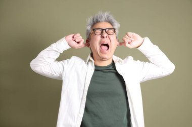 Doğu Asyalı bir işadamının yarım vücut portresi. Koyu yeşil bir arka planda izole edilmiş. Stüdyoda çekilmiş..