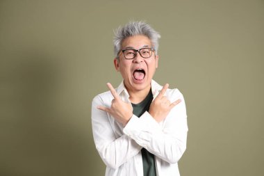 Doğu Asyalı bir işadamının yarım vücut portresi. Koyu yeşil bir arka planda izole edilmiş. Stüdyoda çekilmiş..