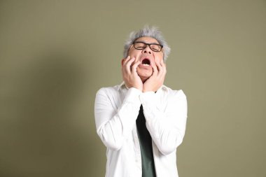 Doğu Asyalı bir işadamının yarım vücut portresi. Koyu yeşil bir arka planda izole edilmiş. Stüdyoda çekilmiş..