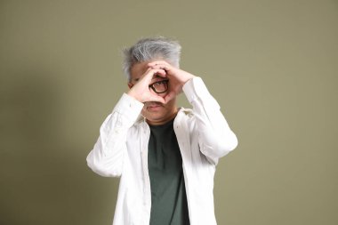 Doğu Asyalı bir işadamının yarım vücut portresi. Koyu yeşil bir arka planda izole edilmiş. Stüdyoda çekilmiş..