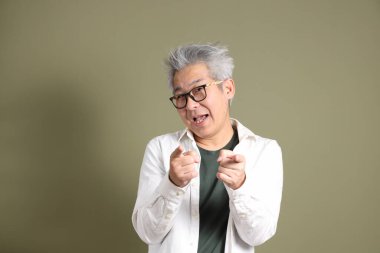 Doğu Asyalı bir işadamının yarım vücut portresi. Koyu yeşil bir arka planda izole edilmiş. Stüdyoda çekilmiş..