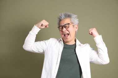 Doğu Asyalı bir işadamının yarım vücut portresi. Koyu yeşil bir arka planda izole edilmiş. Stüdyoda çekilmiş..