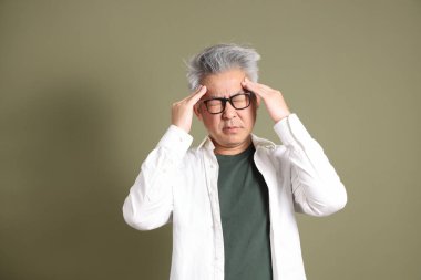 Doğu Asyalı bir işadamının yarım vücut portresi. Koyu yeşil bir arka planda izole edilmiş. Stüdyoda çekilmiş..