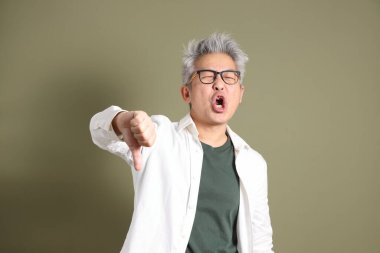 Doğu Asyalı bir işadamının yarım vücut portresi. Koyu yeşil bir arka planda izole edilmiş. Stüdyoda çekilmiş..