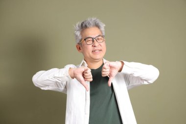 Doğu Asyalı bir işadamının yarım vücut portresi. Koyu yeşil bir arka planda izole edilmiş. Stüdyoda çekilmiş..