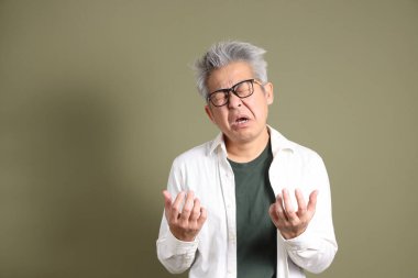 Doğu Asyalı bir işadamının yarım vücut portresi. Koyu yeşil bir arka planda izole edilmiş. Stüdyoda çekilmiş..