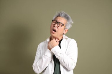 Doğu Asyalı bir işadamının yarım vücut portresi. Koyu yeşil bir arka planda izole edilmiş. Stüdyoda çekilmiş..