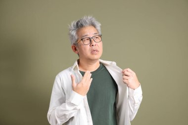 Doğu Asyalı bir işadamının yarım vücut portresi. Koyu yeşil bir arka planda izole edilmiş. Stüdyoda çekilmiş..