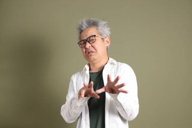 Doğu Asyalı bir işadamının yarım vücut portresi. Koyu yeşil bir arka planda izole edilmiş. Stüdyoda çekilmiş..