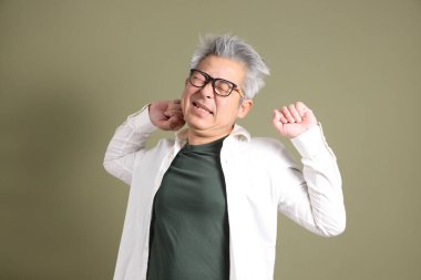 Doğu Asyalı bir işadamının yarım vücut portresi. Koyu yeşil bir arka planda izole edilmiş. Stüdyoda çekilmiş..