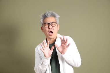 Doğu Asyalı bir işadamının yarım vücut portresi. Koyu yeşil bir arka planda izole edilmiş. Stüdyoda çekilmiş..