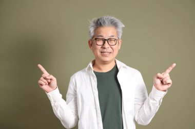 Doğu Asyalı bir işadamının yarım vücut portresi. Koyu yeşil bir arka planda izole edilmiş. Stüdyoda çekilmiş..