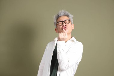 Doğu Asyalı bir işadamının yarım vücut portresi. Koyu yeşil bir arka planda izole edilmiş. Stüdyoda çekilmiş..